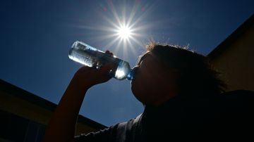 A child sips water from a bottle under a scorching sun on August 30, 2022 in Los Angeles, California. - Forecasters said the mercury could reach as high as 112 Fahrenheit (44 Celsius) in the densely populated Los Angeles suburbs in the next week as a heat dome settles in over parts of California, Nevada and Arizona. (Photo by Frederic J. BROWN / AFP) (Photo by FREDERIC J. BROWN/AFP via Getty Images)