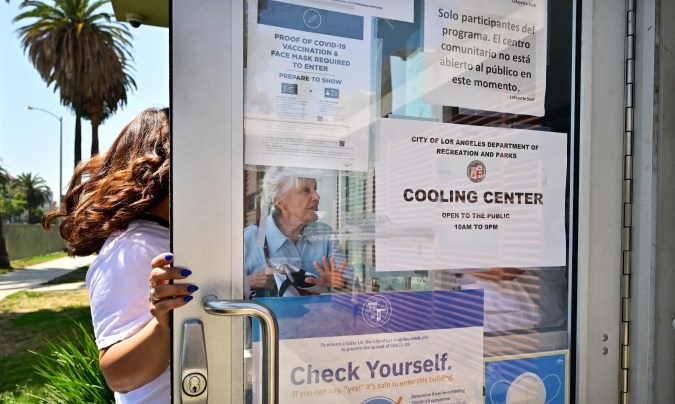 People make their way out of the heat into a cooling center at the Lafayette Recreation Center in Los Angeles, California, on September 2, 2022. - Nine cooling centers opened this week in Los Angeles as Southern California deals with triple-digit temperatures during a heatwave due to last through the Labor Day weekend. (Photo by Frederic J. BROWN / AFP) (Photo by FREDERIC J. BROWN/AFP via Getty Images)