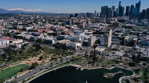 An aerial image shows snow capped mountains on the horizon with the downtown Los Angeles skyline following heavy rain from winter storms as seen above MacArthur Park on March 2, 2023 in Los Angeles, California. (Photo by Patrick T. Fallon / AFP) (Photo by PATRICK T. FALLON/AFP via Getty Images)