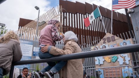 An asylum seeker girl from Russia waits for US Customs and Border Protection agents to allow her enter the country at the San Ysidro crossing port on the US-Mexico border, as seen from Tijuana, Baja California state, Mexico on May 31, 2023. Some 250 asylum seekers from several countries are waiting at the pedestrian crossing in hopes to be processed by US authorities. (Photo by Guillermo Arias / AFP) (Photo by GUILLERMO ARIAS/AFP via Getty Images)