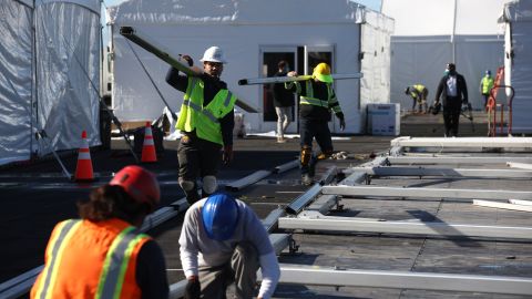 OAKLAND, CALIFORNIA - FEBRUARY 12: Workers erect tents as they set up the new mass vaccination site at the Oakland Coliseum on February 12, 2021 in Oakland, California. A mass COVID-19 vaccination site is set to open on February 16th at the Oakland Coliseum and will provide at least 6,000 shots per day. The site is part of U.S. President Joe Biden's effort to open 100 vaccination sites across the country in his first 100 days in office. The site will be operated by the Federal Emergency Management Agency (FEMA) and the California Governor’s Office of Emergency Services. (Photo by Justin Sullivan/Getty Images)