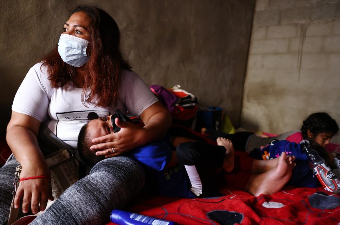 Una madre sostiene a su hijo mientras descansan en un refugio para migrantes el 21 de julio de 2021 en Tijuana, México.