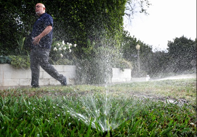 LOS ANGELES, CALIFORNIA - JULY 27: Los Angeles Department of Water and Power (LADWP) water conservation specialist Damon Ayala walks while inspecting a sprinkler system, which is operating in violation of the water conservation ordinance, on July 27, 2022 in Los Angeles, California. Amid California’s ongoing drought, Ayala and other public servants with the Water Conservation Response Unit patrol the city for lawn watering violations and respond to water waste reports from members of the community. Following increased lawn watering restrictions due to the drought, Angelenos recorded the lowest all-time water use for any June recorded in the City of Los Angeles. (Photo by Mario Tama/Getty Images)