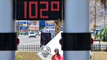 Un hombre se retrata junto a un termómetro que muestra 102 F en Baker, California, el 11 de julio de 2023.