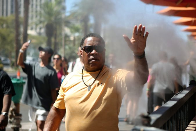 Un peatón se refresca con los aspersores de agua en las aceras durante una ola de calor en Las Vegas, Nevada, el 14 de julio de 2023.