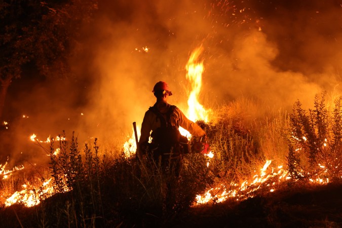 TOPSHOT - A firefighter monitors and sets a controled burn as the Rabbit Fire scorched over 7,500 acres in Moreno Valley, Riverside County, California on July 15, 2023. Brutally high temperatures threatened tens of millions of Americans July 15, as numerous cities braced to break records under a relentless heat dome that has baked parts of the country all week. The National Weather Service warned of an "extremely hot and dangerous weekend," with daytime highs reaching up to 116 Fahrenheit (47 degres celsius). (Photo by DAVID SWANSON / AFP) (Photo by DAVID SWANSON/AFP via Getty Images)