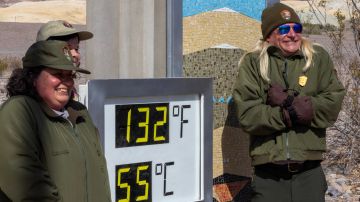 FURNACE CREEK, CALIFORNIA - JULY 16: U.S. Park Ranger Eric Henson (R) pretends to be cold while posing next to the unofficial thermometer at the Furnace Creek Visitor Center indicating a temperature of 132 degrees Fahrenheit, which is known for showing temperatures that are inaccurately higher than the official temperature, on a day that could set a new world heat record in Death Valley National Park on July 16, 2023 near Furnace Creek, California. Weather forecasts for tomorrow call for a high temperature of 129 degrees F and possibly as high as 131. Previously, the highest temperature reliably recorded on Earth was 129.2 F (54C) in Death Valley in 2013. A century earlier, a high temperature in Death Valley reportedly reached 134 F but many modern weather experts have rejected that claim along with other high summer temperatures reported in the region that year. (Photo by David McNew/Getty Images)