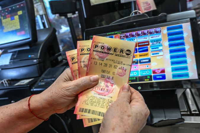 A woman holds Powerball lottery tickets inside a store in Homestead, Florida on July 19, 2023. The Powerball jackpot has reached 1 billion USD for the July 19, 2023, drawing, which has only happened two times before in the history of the game. (Photo by GIORGIO VIERA / AFP) (Photo by GIORGIO VIERA/AFP via Getty Images)
