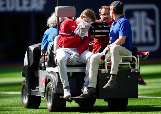 Taylor Ward siendo retirado del partido tras pelotazo. Foto: Mark Blinch/Getty Images.