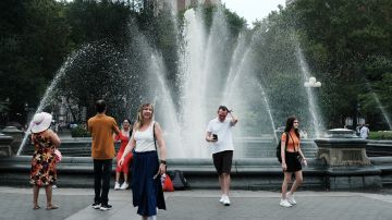 La gente intenta refrescarse junto a la fuente en Washington Square Park en Nueva York durante la ola de calor.