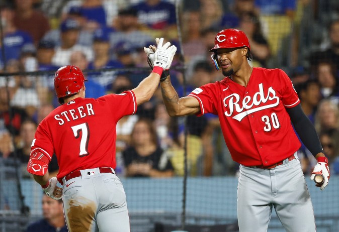 Spencer Steer de los Rojos de Cincinnati celebra un jonrón con Will Benson #30 contra los Dodgers de Los Ángeles en la séptima entrada en el Dodger Stadium el 28 de julio de 2023 en Los Ángeles, California. Foto: Ronald Martínez/Getty Images.