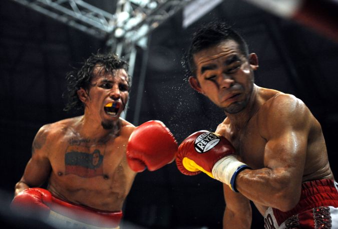 El venezolano campeón mundial de peso ligero de la AMB Edwin "El Inca" Valero (L) y el retador mexicano Héctor Velásquez intercambian golpes durante una pelea por el título mundial de peso ligero de la AMB en Caracas el 20 de diciembre de 2009. Foto: JUAN BARRETO/AFP via Getty Images.