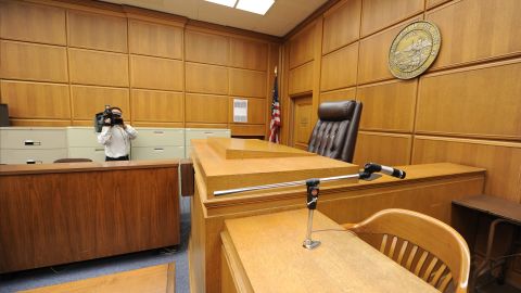 A cameraman records the judge's podium in a courtroom closed due to budget cuts and layoffs, at the Stanley Mosk Courthouse in downtown Los Angeles on March 16, 2009. Beset by an unprecedented budget crisis, the LA Superior Court, the largest trial court system in the US, laid off 329 employees and announced the closure of 17 courtrooms, with more of both expected in the future. AFP PHOTO/Robyn BECK (Photo credit should read ROBYN BECK/AFP via Getty Images)