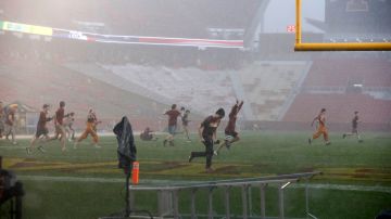 Los estudiantes de Iowa State Cyclones corren hacia el campo de fútbol durante una tormenta en el estadio Jack Trice el 14 de septiembre de 2019 en Ames, Iowa.