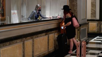 A hotel guest stands at the front desk at The Pierre, A Taj Hotel, New York on September 28, 2020 in New York City. - John Farrell and his wife booked a $1,000 room in the morning and were in New York hours later for their one-night stay. The couple is part of a new local and last-minute clientele keeping the lights on at the city's most luxurious hotels now that the coronavirus has chased off the international jet set. (Photo by Angela Weiss / AFP) (Photo by ANGELA WEISS/AFP via Getty Images)