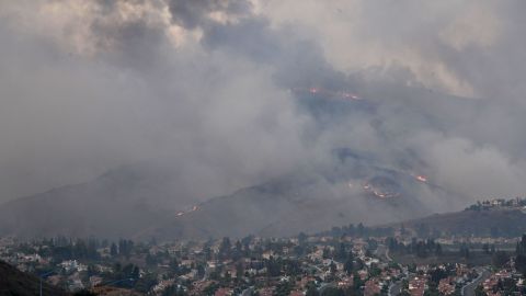 Fire and smoke from the Blue Ridge Fire rises over homes in Yorba Linda, California, October 26, 2020. - Some 60,000 people fled their homes near Los Angeles on October 26 as a fast-spreading wildfire raged across more than 7,200 acres (3,000 hectares), blocking key roadways and critically injuring two firefighters. (Photo by Robyn Beck / AFP) (Photo by ROBYN BECK/AFP via Getty Images)