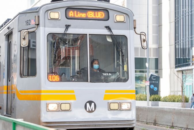 A woman wearing a face mask drives a Metro line train in the downtown area on March 8, 2021 in Los Angeles, California. (Photo by VALERIE MACON / AFP) (Photo by VALERIE MACON/AFP via Getty Images)