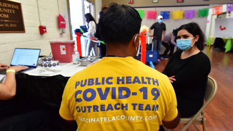 A woman points to her arm to receive her booster shot at a Covid vaccination and testing site decorated for Cinco de Mayo at Ted Watkins Park in Los Angeles on May 5, 2022. - Covid cases in Los Angeles County have topped 3,000 for the first time since mid-February with cases up nearly 300 percent in the past month, sparking concern of a potential "sixth wave" pandemic in the US. (Photo by Frederic J. BROWN / AFP) (Photo by FREDERIC J. BROWN/AFP via Getty Images)