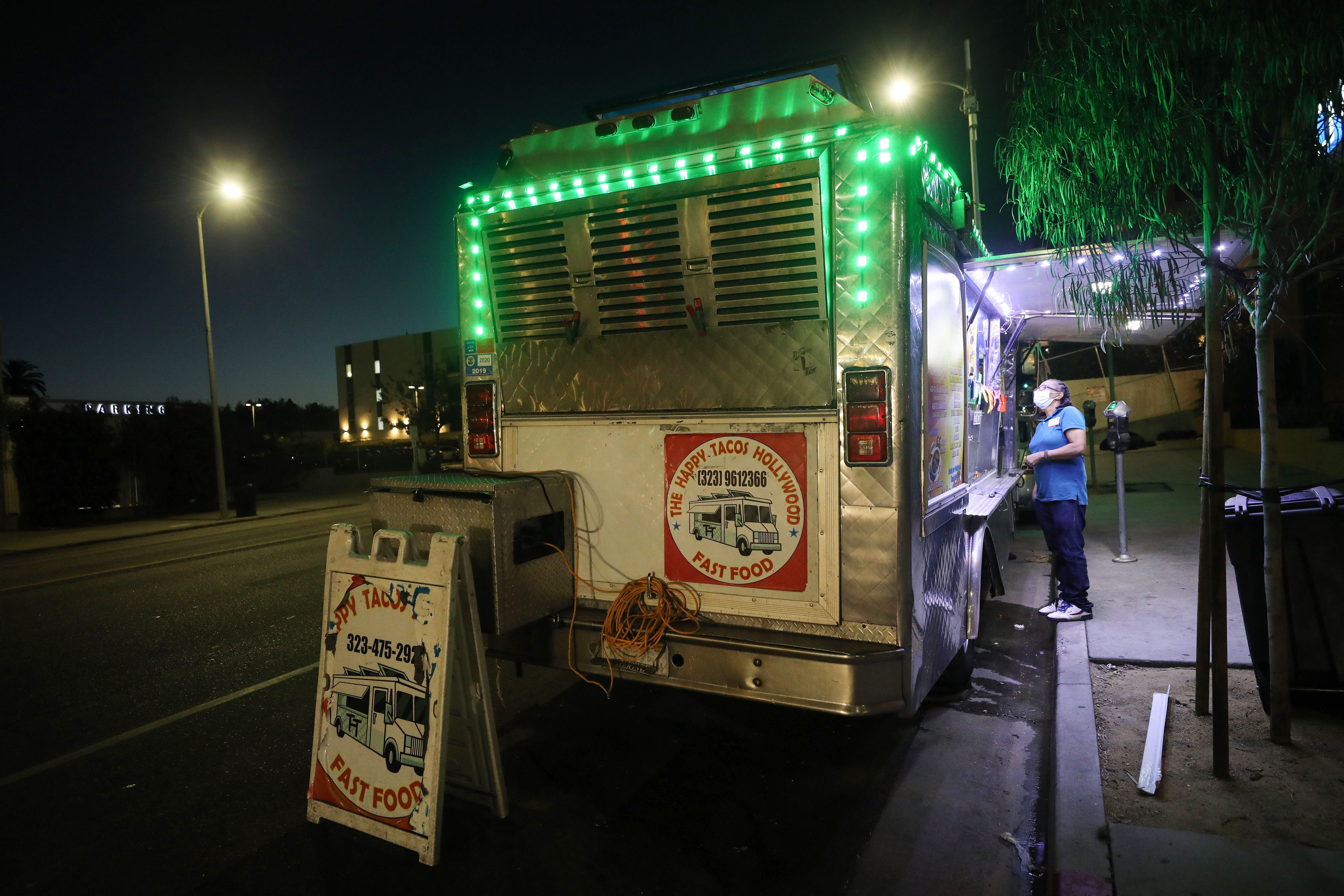 LOS ANGELES, CALIFORNIA - JULY 01: A customer orders from a taco truck amid the COVID-19 pandemic on July 1, 2020 in Los Angeles, California. California Governor Gavin Newsom ordered indoor dining restaurants to close again today in Los Angeles County and 18 other counties for at least three weeks amid a surge in new coronavirus cases. Restaurants and food trucks may remain open for takeout and drive-through orders. (Photo by Mario Tama/Getty Images)