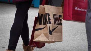 CHICAGO, ILLINOIS - DECEMBER 21: A shopper leaves a Nike store along the Magnificent Mile shopping district with a purchase on December 21, 2022 in Chicago, Illinois. Nike's stock price jumped more than 10 percent today after the sportswear maker announced earnings far exceeding expectations. (Photo by Scott Olson/Getty Images)