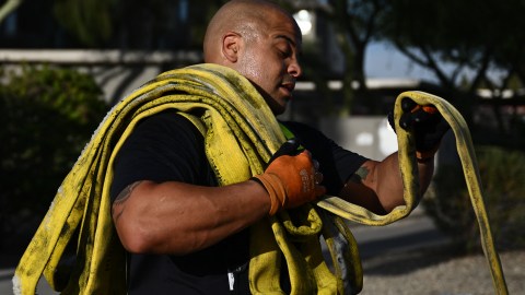 Un bombero suda mientras recoge una manguera tras apagar un incendio en medio de la ola de calor en Phoenix, Arizona.