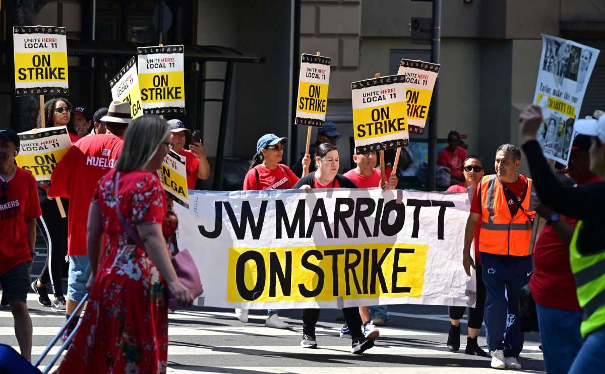 Hotel workers on strike hold placards outside the InterContinental Hotel in downtown Los Angeles, California on August 7, 2023. Hundreds of hotel workers in Southern California walked off the job on Monday, demanding higher pay and better benefits. (Photo by Frederic J. BROWN / AFP) (Photo by FREDERIC J. BROWN/AFP via Getty Images)