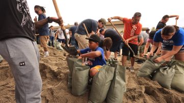 Los residentes palean y llenan sacos de arena en la ciudad de Indio cuando el huracán Hilary se acerca a California.