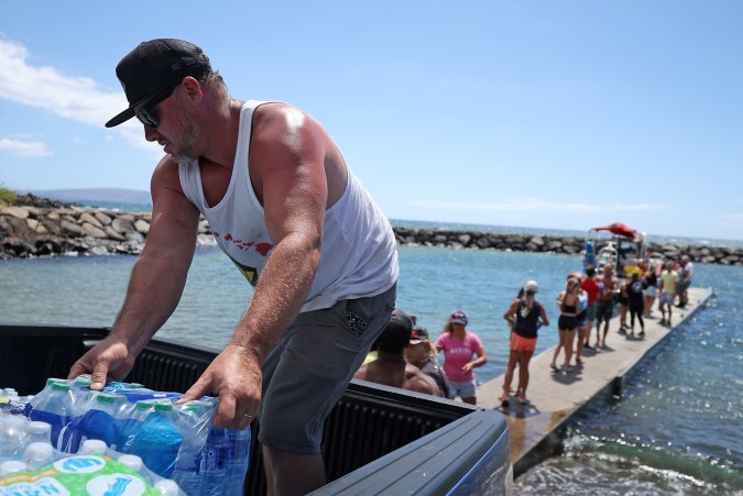 Voluntarios cargan agua en un bote para ser transportado al oeste de Maui desde el embarcadero de Kihei el 13 de agosto de 2023 en Kihei, Hawaii. Foto: Justin Sullivan/Getty Images.