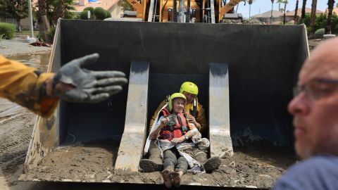 TOPSHOT - Cathedral City Fire Department rescues residents in a bulldozer following heavy rains from Tropical Storm Hilary in Cathedral City, California, on August 21, 2023. Tropical Storm Hilary drenched Southern California with record rainfall, shutting down schools, roads and businesses before edging in on Nevada on August 21, 2023. California Governor Gavin Newsom had declared a state of emergency over much of the typically dry area, where flash flood warnings remained in effect until this morning. (Photo by DAVID SWANSON / AFP) (Photo by DAVID SWANSON/AFP via Getty Images)