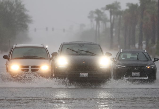 PALM SPRINGS, CALIFORNIA - AUGUST 20: Vehicles drive along a flooded street as Tropical Storm Hilary approaches on August 20, 2023 in Palm Springs, California. Southern California is under a first-ever tropical storm warning as Hilary nears, with parts of California, Arizona and Nevada preparing for flooding and heavy rains. All California state beaches have been closed in San Diego and Orange counties in preparation for the impacts from the storm, which has been downgraded from hurricane status. (Photo by Mario Tama/Getty Images)