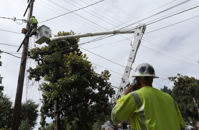 SIERRA MADRE, CALIFORNIA - AUGUST 21: In an aerial view, utility workers repair an electrical line that was damaged by a falling tree during tropical storm Hilary on August 21, 2023 in Sierra Madre, California. Much of Southern California and parts of Arizona and Nevada are cleaning up after being impacted by the tropical storm that brought several inches of rain that flooded roadways and winds that toppled trees and power lines across the region. (Photo by Justin Sullivan/Getty Images)