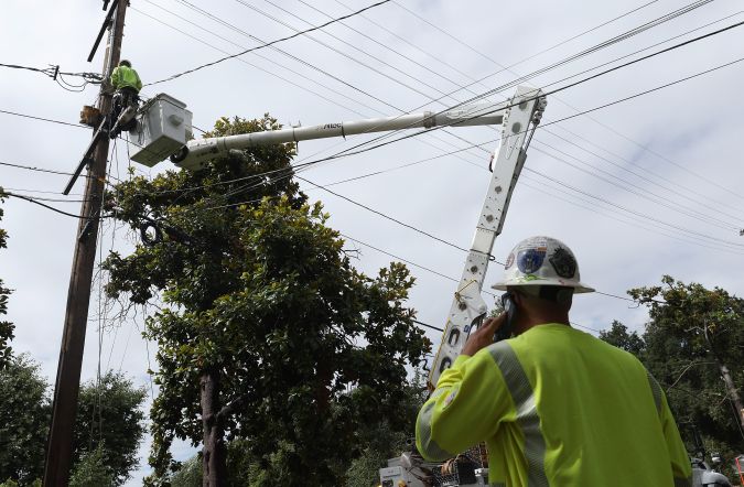 SIERRA MADRE, CALIFORNIA - AUGUST 21: In an aerial view, utility workers repair an electrical line that was damaged by a falling tree during tropical storm Hilary on August 21, 2023 in Sierra Madre, California. Much of Southern California and parts of Arizona and Nevada are cleaning up after being impacted by the tropical storm that brought several inches of rain that flooded roadways and winds that toppled trees and power lines across the region. (Photo by Justin Sullivan/Getty Images)