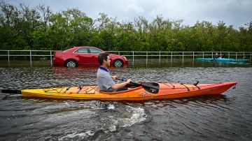 TOPSHOT - Residents use kayaks to travel on a flooded road in Tampa, Florida, on August 30, 2023, after Hurricane Idalia made landfall. Idalia barreled into the northwest Florida coast as a powerful Category 3 hurricane on Wednesday morning, the US National Hurricane Center said. "Extremely dangerous Category 3 Hurricane #Idalia makes landfall in the Florida Big Bend," it posted on X, formerly known as Twitter, adding that Idalia was causing "catastrophic storm surge and damaging winds." (Photo by Miguel J. Rodriguez Carrillo / AFP) (Photo by MIGUEL J. RODRIGUEZ CARRILLO/AFP via Getty Images)