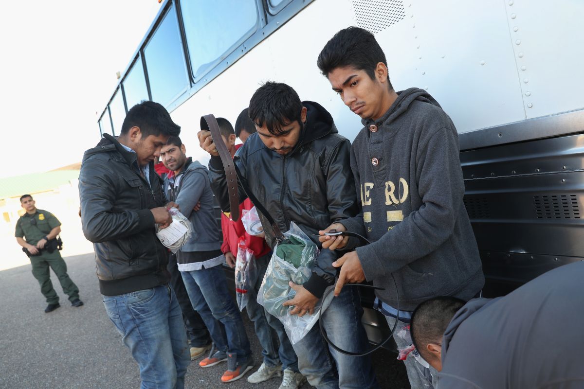 Inmigrantes detenidos revisan sus pertenencias antes de ser expulsados de EE.UU.