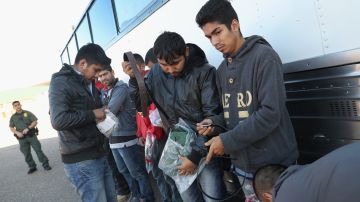 Inmigrantes detenidos revisan sus pertenencias antes de ser expulsados de EE.UU.