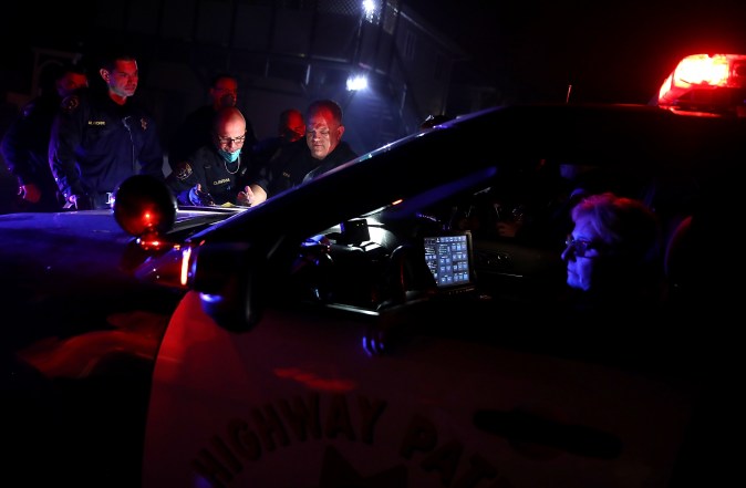 SONOMA, CA - OCTOBER 11: California Highway Patrol officers look over a map of a neighborhood as they go door-to-door to ask residents to voluntarily evacuate as a wildfire approaches on October 11, 2017 in Sonoma, California. Twenty one people have died in wildfires that have burned tens of thousands of acres and destroyed over 3,000 homes and businesses in several Northen California counties. (Photo by Justin Sullivan/Getty Images)
