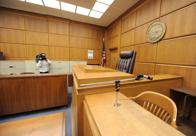 A cameraman records the judge's podium in a courtroom closed due to budget cuts and layoffs, at the Stanley Mosk Courthouse in downtown Los Angeles on March 16, 2009. Beset by an unprecedented budget crisis, the LA Superior Court, the largest trial court system in the US, laid off 329 employees and announced the closure of 17 courtrooms, with more of both expected in the future. AFP PHOTO/Robyn BECK (Photo credit should read ROBYN BECK/AFP via Getty Images)