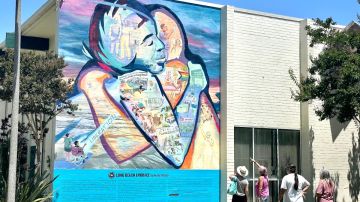 Residentes de Long Beach se detienen a admirar el recién inaugurado mural 'Long Beach te abraza'.