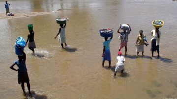 Mujeres cruzan el río Masacre, de aguas comunes de Haití y República Dominicana.