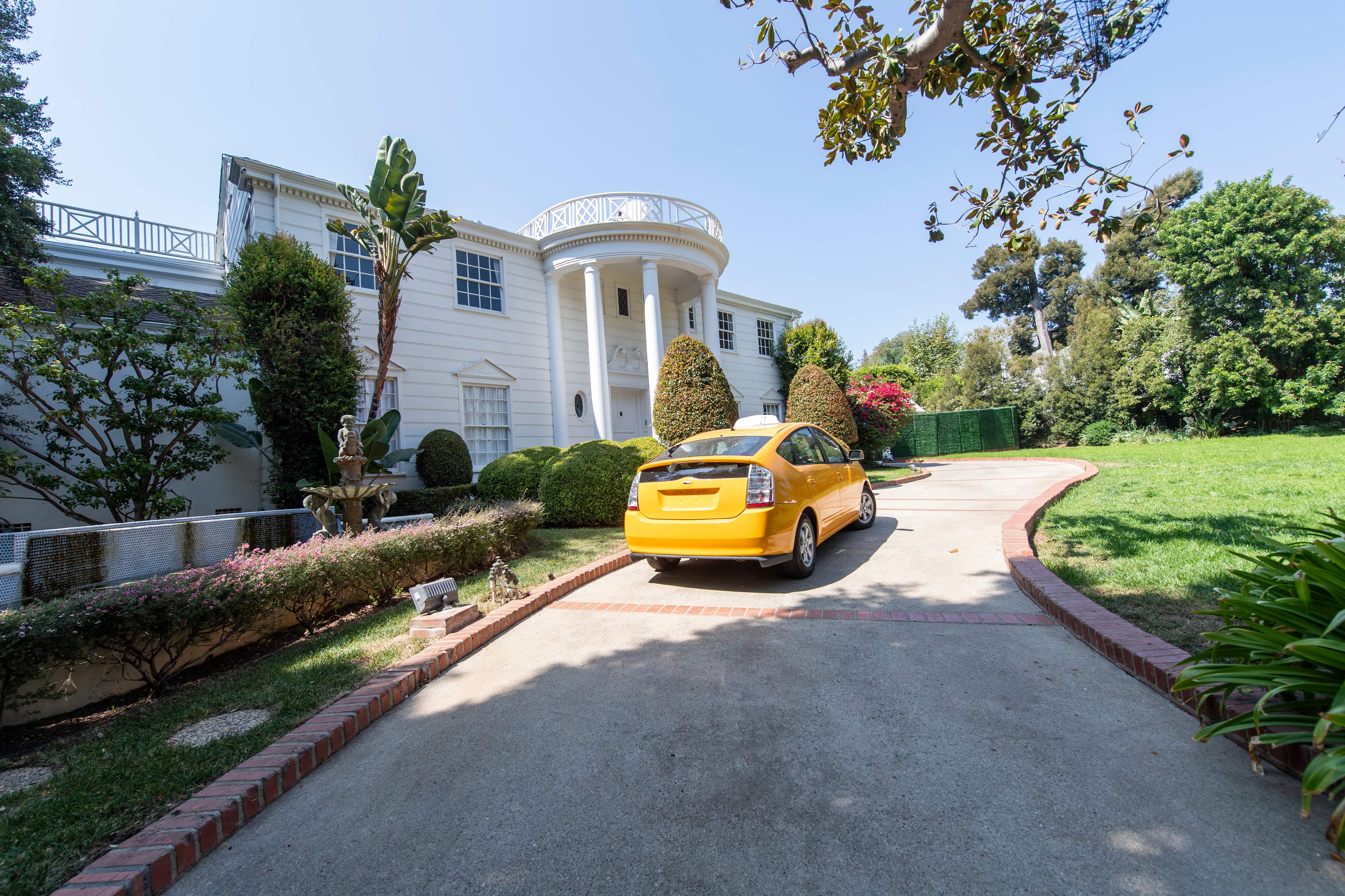 A yellow cab drives by the "Fresh Prince of Bel Air" mansion, just like in the series opening credits, on September 24, 2020, in Brentwood, California. - The "Fresh Prince of Bel-Air" series, which launched Will Smith's career on television, is celebrating its 30th anniversary. The house where the Banks family lives in the show is available for rent via Airbnb, for $30 a night, for 30 days. The house, which is 6400 sq.ft and worth more than $6 millions, was used for exterior establishing shots in the series, but interior live-actions was shot in a Los Angeles studio. (Photo by VALERIE MACON / AFP) (Photo by VALERIE MACON/AFP via Getty Images)