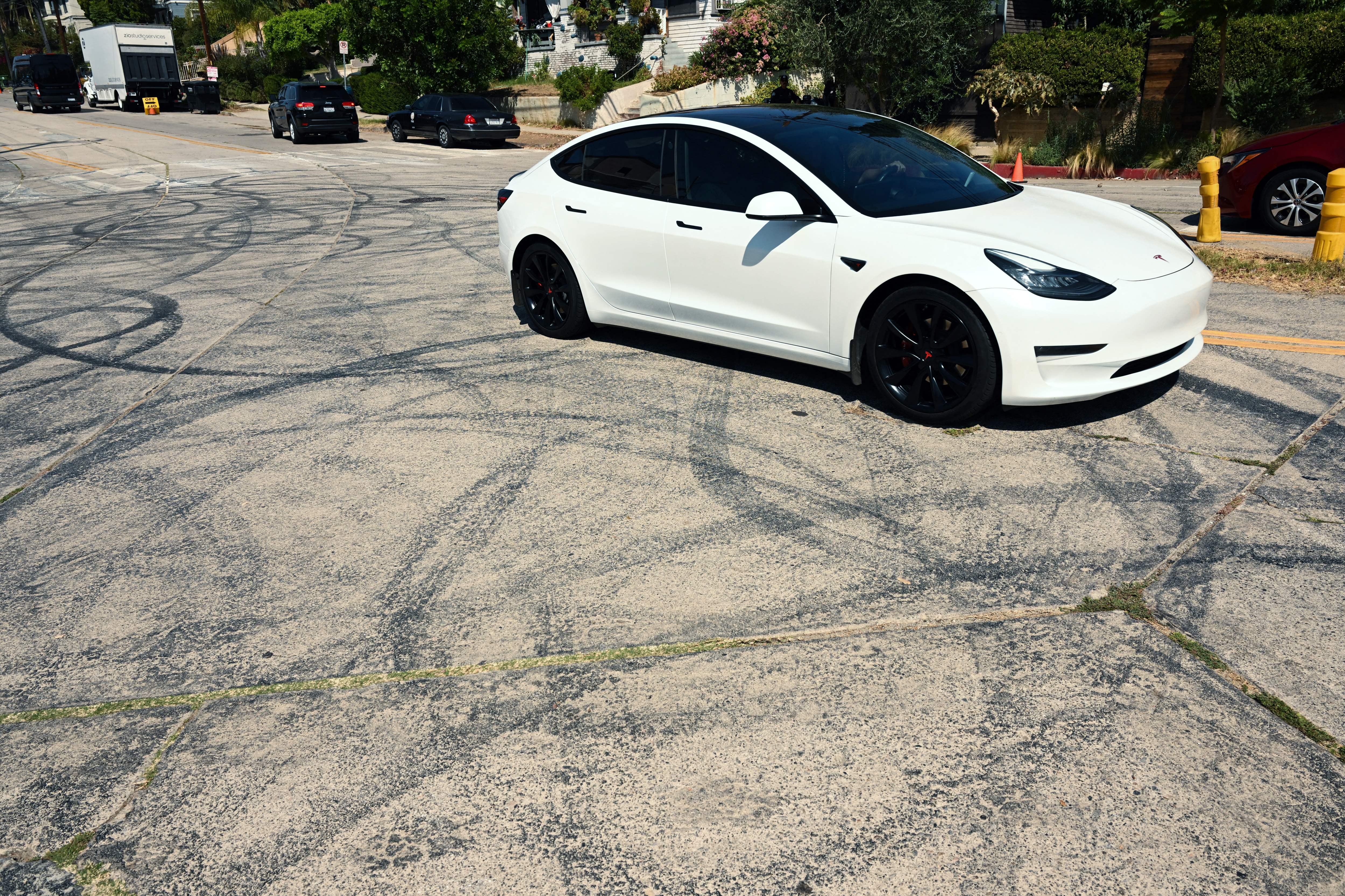 A Tesla electric vehicle drives past tire skid marks from other drivers doing burnouts and "donuts" on Bellevue Ave near Bob's Market where area residents are protesting an increase in street racing takeovers and the latest Fast and Furious movie being filmed in the Angelino Heights neighborhood of Los Angeles, California on August 26, 2022. - A Los Angeles neighborhood featured in the "Fast and Furious" movies held protests against the filming of the franchise's latest installment August 26, 2022, claiming the community has been blighted by a spate of illegal and dangerous street racing. (Photo by Patrick T. FALLON / AFP) (Photo by PATRICK T. FALLON/AFP via Getty Images)