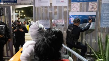 Un policía de México escanea la aplicación de asilo en CBP One de un inmigrante, antes de autorizar su paso a EE.UU.