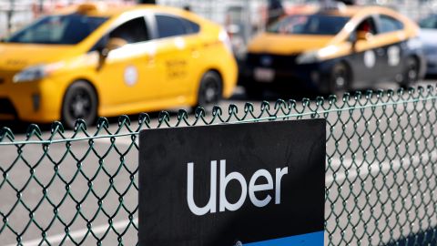 LOS ANGELES, CALIFORNIA - FEBRUARY 08: An Uber rideshare sign is posted nearby as taxis wait to pick up passengers at Los Angeles International Airport (LAX) on February 8, 2023 in Los Angeles, California. Ride-hailing giant Uber has beaten estimates with a strong revenue and adjusted earnings report with quarterly revenue hitting $8.6 billion, 49 percent higher than the same period last year. (Photo by Mario Tama/Getty Images)