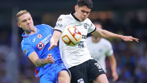 Israel Reyes del América disputa un balón con Carlos Rotondi de Cruz Azul.