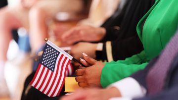 Una persona sostiene la bandera estadounidense durante una ceremonia de naturalización.