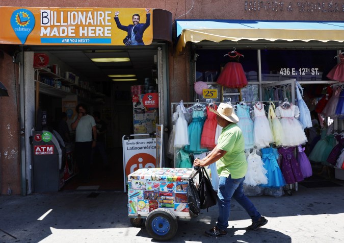 LOS ANGELES, CALIFORNIA - JULY 20: An ice cream vendor walks past Las Palmitas Mini Market on July 20, 2023 in Los Angeles California. The $1.08 billion winning Powerball ticket was sold at the Las Palmitas Mini Market for the July 19th drawing. The jackpot is the third largest in Powerball history and was picked after three months of drawings without a winner. The mini market is located in the downtown Fashion District close to Skid Row. (Photo by Mario Tama/Getty Images)