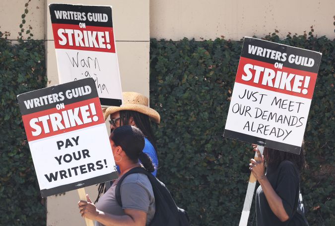 BURBANK, CALIFORNIA - AUGUST 16: Striking WGA (Writers Guild of America) members picket outside Warner Bros. Studio on August 16, 2023 in Burbank, California. The Writers Guild of America reportedly met with the Alliance of Motion Picture and Television Producers yesterday with a response to the latest offer from the Hollywood studios over a collective bargaining agreement. (Photo by Mario Tama/Getty Images)