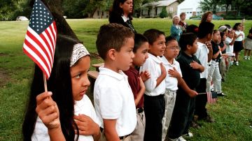 Una clase de niños latinos recita el juramento a la bandera en su escuela en Texas.
