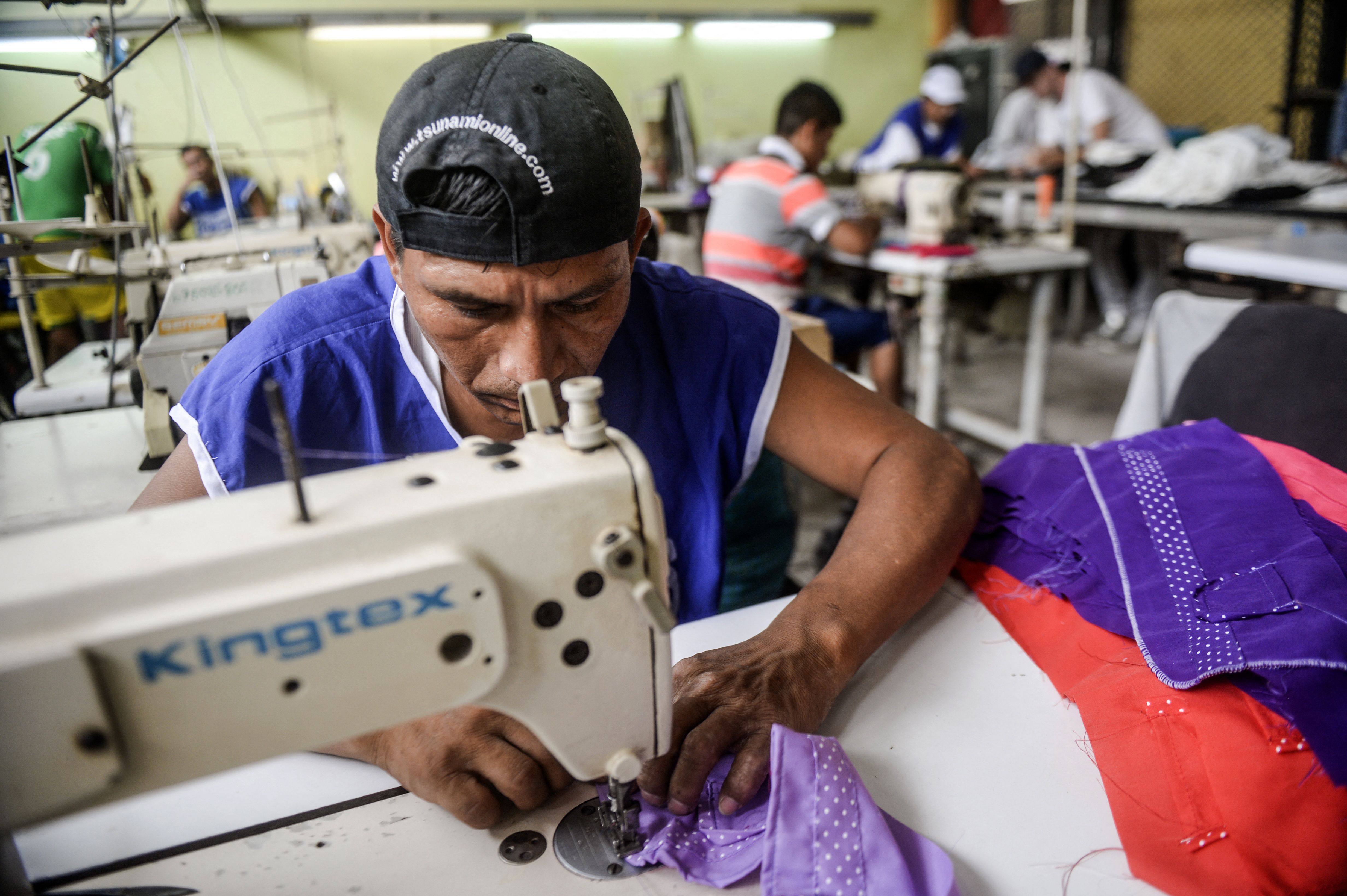 An inmate taking part in the social project "Pieta", led by French designer Thomas Jacob, sews at the San Pedro prision in Lima on March 1, 2016. - With the help of 29-year-old French fashionista Jacob who cut his teeth at Chanel, inmates at San Pedro and a women's prison across town, Santa Monica, have launched their own clothing label, seeking to bring their urban style to the world and find redemption in fashion. (Photo by ERNESTO BENAVIDES / AFP) (Photo by ERNESTO BENAVIDES/AFP via Getty Images)