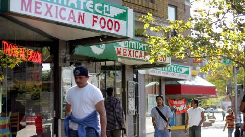 Washington, UNITED STATES: People walk past a Mexican restaurant 02 October 2006 in the Adams Morgan neighborhood of Washington, DC, where one comes in touch with the myriad sights, sounds of music and aroma of cooking from the Latino world. Latin-American residents of Washington, DC share the condemnation with residents and leaders of South and Central America over the building of a wall on the US-Mexico border. The US Congress on 29 September 2006 approved the construction of a 700-mile (1,125 kilometer) wall along the border, over which tens of thousands of mainly Latin American illegal immigrants pass each year. AFP PHOTO / TIM SLOAN (Photo credit should read TIM SLOAN/AFP via Getty Images)